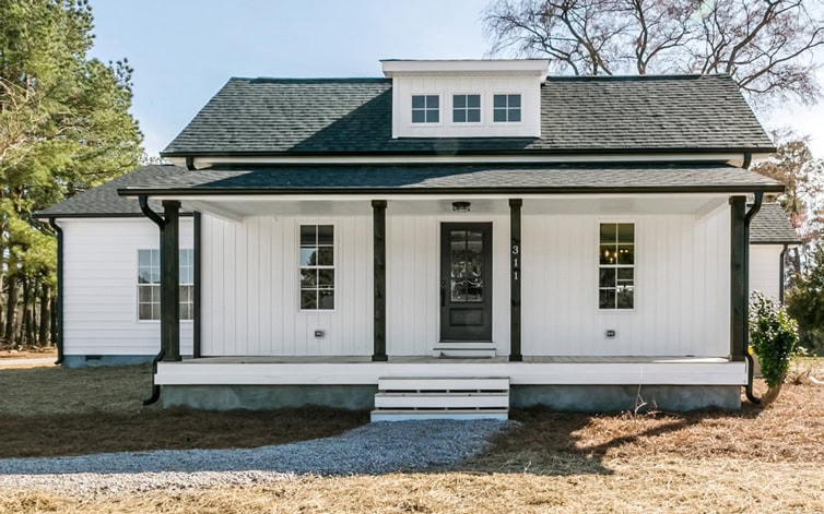 Beautiful white farmhouse with black accents and front porch.